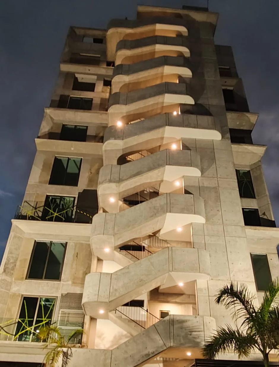 Fachada de REVIER con la escalera escultórica iluminada